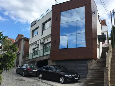 two cars parked in front of a building at Apel Luxury in Niš