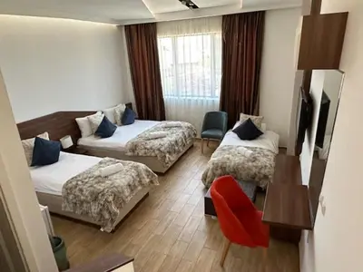 a hotel room with two beds and a couch at Apel Luxury in Niš