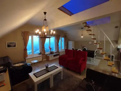 a living room with a red chair and a red couch at Apartment Jelena in Kopaonik
