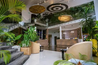 a lobby with potted plants and stairs in a building at Hotel Crystal Light in Niš
