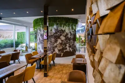 a restaurant with tables and chairs and a large window at Hotel Crystal Light in Niš