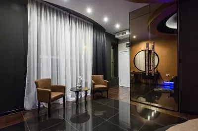 a room with chairs and a table and a window at Hotel Crystal Light in Niš