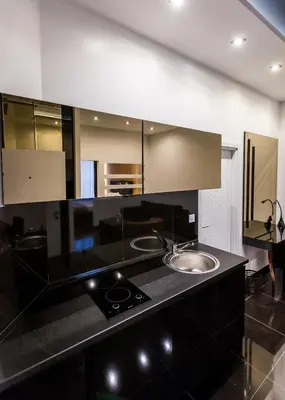 a bathroom with a black counter top with a sink at Hotel Crystal Light in Niš