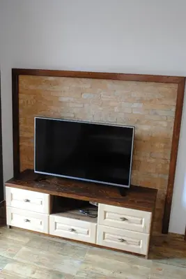 a flat screen tv sitting on top of a wooden entertainment center at Vila Tisa in Kopaonik