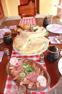 a wooden table with plates of food on it at Stara Planina Vila Vesela kuca in Jalovik Izvor