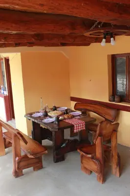 a dining room with a wooden table and chairs at Stara Planina Vila Vesela kuca in Jalovik Izvor