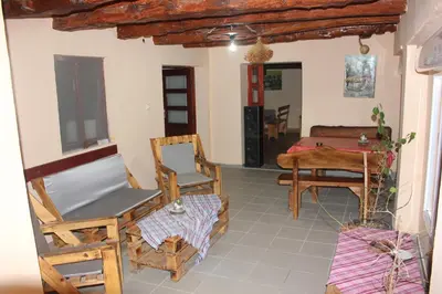 a living room with rocking chairs and a piano at Stara Planina Vila Vesela kuca in Jalovik Izvor