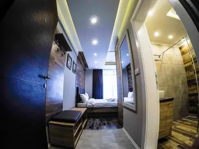 a bathroom with a mirror and a bed in a room at SM Apartments Kopaonik in Kopaonik