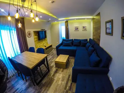 a living room with a blue couch and a table at SM Apartments Kopaonik in Kopaonik
