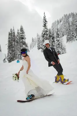 a bride and groom in the snow on a snowboard at SM Apartments Kopaonik in Kopaonik