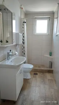 a bathroom with a sink and a toilet and a window at Apartman Rada in Pirot