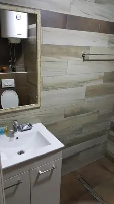 a bathroom with a sink and a mirror at Apartman Mia Milmari in Kopaonik