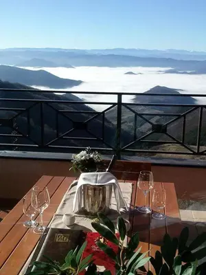 a table with wine glasses on top of a balcony at Apartman Mia Milmari in Kopaonik