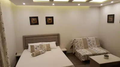 a small room with a bed and a chair at Apartman Mia Milmari in Kopaonik