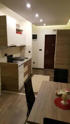 a kitchen and dining room with a table and chairs at Apartman Mia Milmari in Kopaonik