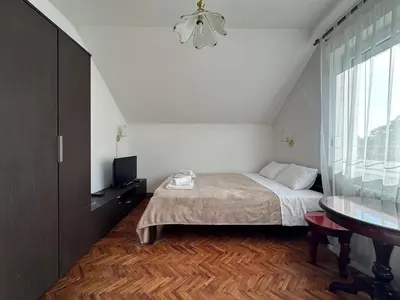 a bedroom with a bed and a table and a window at Pansion 