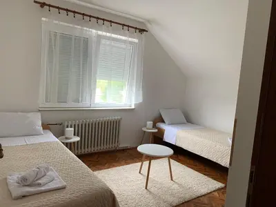 a small bedroom with two beds and a window at Pansion 