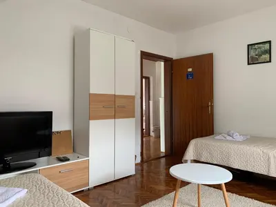 a room with a bedroom with a bed and a tv at Pansion 