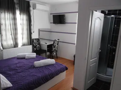 a bedroom with a purple bed with two towels on it at Prenociste Bojan 017 in Vranje