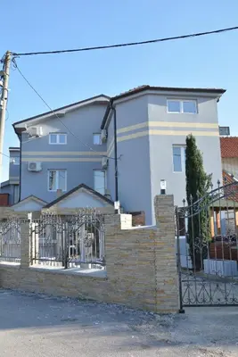 a house with a fence in front of it at Prenociste Bojan 017 in Vranje