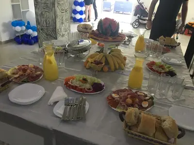 a table with plates of food and bottles of orange juice at Prenociste Bojan 017 in Vranje