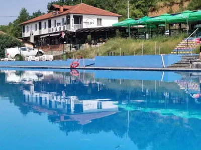 a pool of blue water with a building in the background at Apartments Park 2016 in Surdulica