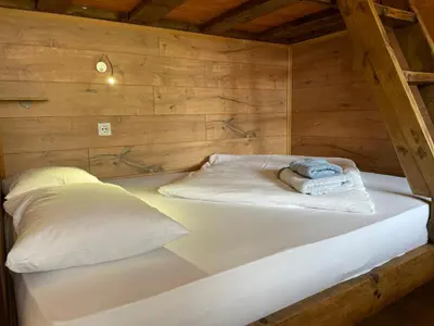 a large bed in a wooden room with a pillow at Apartments Park 2016 in Surdulica