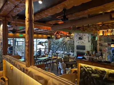 a restaurant with wooden walls and tables and chairs at Apartments Park 2016 in Surdulica
