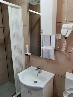 a bathroom with a white sink and a mirror at JOKSIM Rooms&Restaurant in Kuršumlija