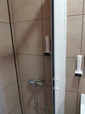 a bathroom with a shower with a shower head at JOKSIM Rooms&Restaurant in Kuršumlija