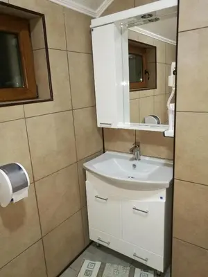 a bathroom with a white sink and a mirror at JOKSIM Rooms&Restaurant in Kuršumlija