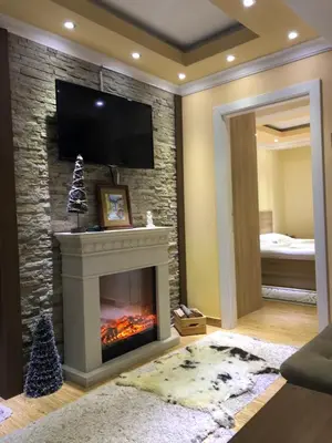 a living room with a fireplace with a tv above it at Apartment Elvir in Kopaonik