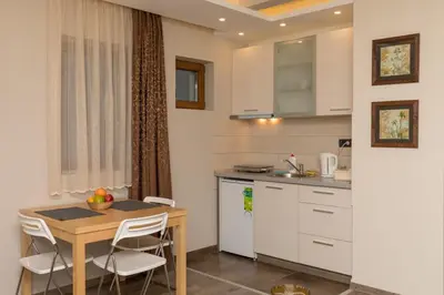 a small kitchen with a table and a table and chairs at Apartment Milmari Sunny View G3 in Kopaonik