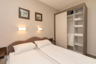a bedroom with a white bed and a closet at Apartment Milmari Sunny View G3 in Kopaonik