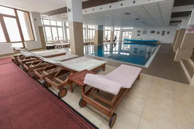 a pool with a group of chairs and a swimming pool at Apartment Milmari Sunny View G3 in Kopaonik