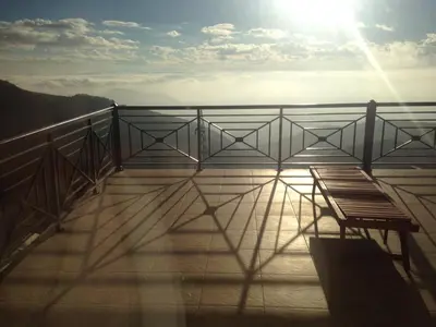 a balcony with a bench and the sun in the sky at Apartment Milmari Sunny View G3 in Kopaonik