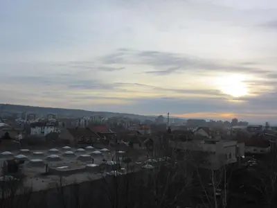 a view of a city with the sun setting at Studio Ema in Niš