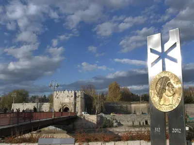 a monument with a cross on it in front of a bridge at Studio Ema in Niš