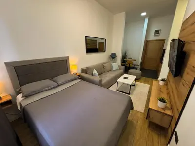 a bedroom with a large bed and a living room at Vip Apartments Kopaonik in Kopaonik