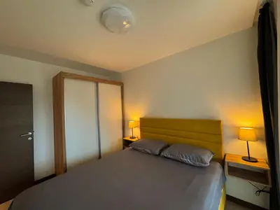 a bedroom with a bed with two pillows and two lamps at Vip Apartments Kopaonik in Kopaonik