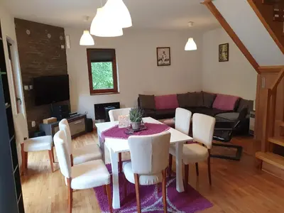 a living room with a dining room table and chairs at Lodge Zeleni svet in Crni Vrh