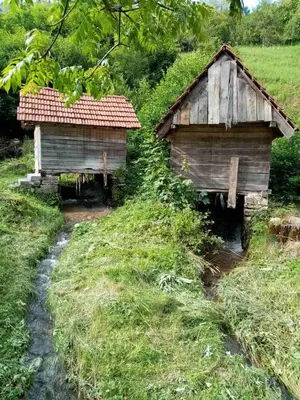 two wooden huts on the side of a field at KOPAONIK-GONDOLA 100m in Brzeće