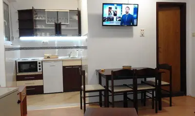 a kitchen with a table and a tv on the wall at KOPAONIK-GONDOLA 100m in Brzeće