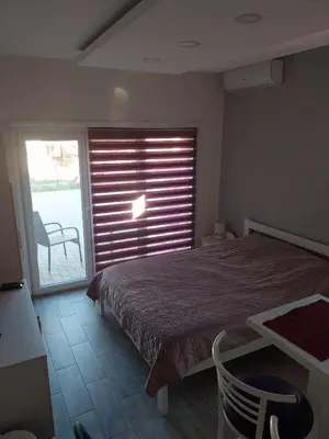 a bedroom with a bed and a table and a window at Apartment Azulmburgo in Vrnjačka Banja