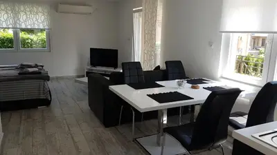 a living room with a white table and black chairs at Apartment Azulmburgo in Vrnjačka Banja