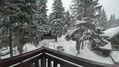 a balcony with snow covered trees and a house at Apartments Zed Vila Zvoncica in Kopaonik