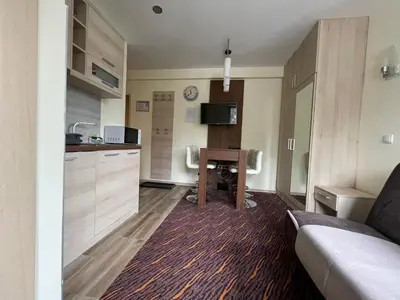 a room with a kitchen with a desk and a couch at Apartment Koko in Kopaonik