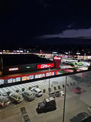a parking lot with cars parked in front of a stadium at MB Apartments in Jagodina
