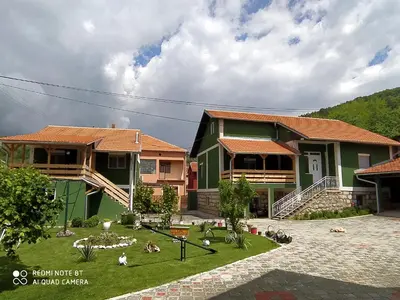 a group of houses with people sitting in the grass at Guest House Vila Banjica in Pirot