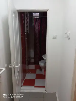 a bathroom with a toilet and a red and white tile floor at Guest House Vila Banjica in Pirot